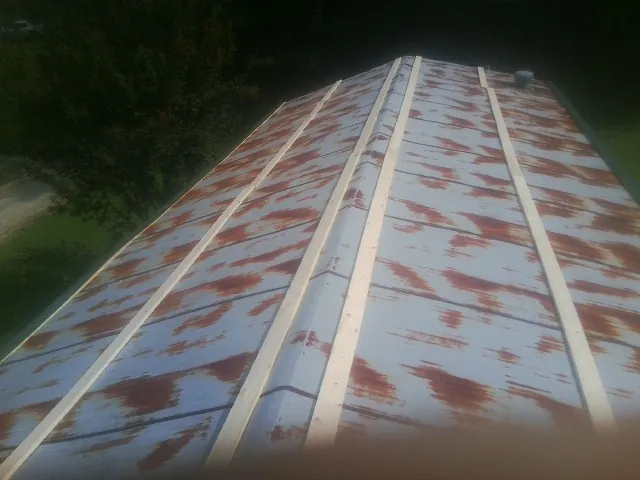 Rusted metal roof panels with new wood purlins before replacement — Storm Damage Roof Repair in Avinger by Roofing Brothers