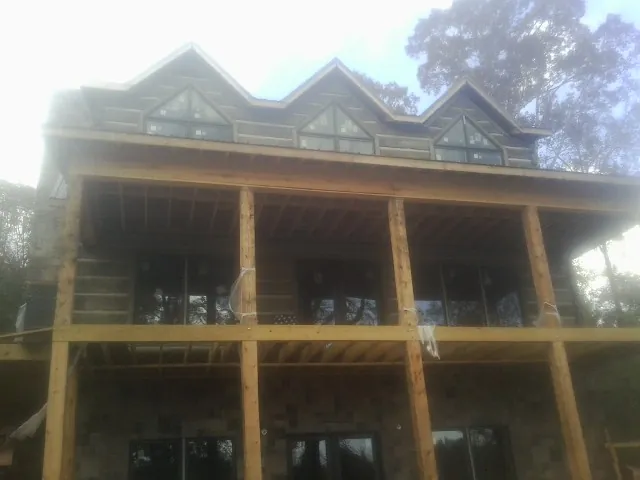 Dormers and porch framing on a large log home under construction — Roof Coating work by our crew in Avinger