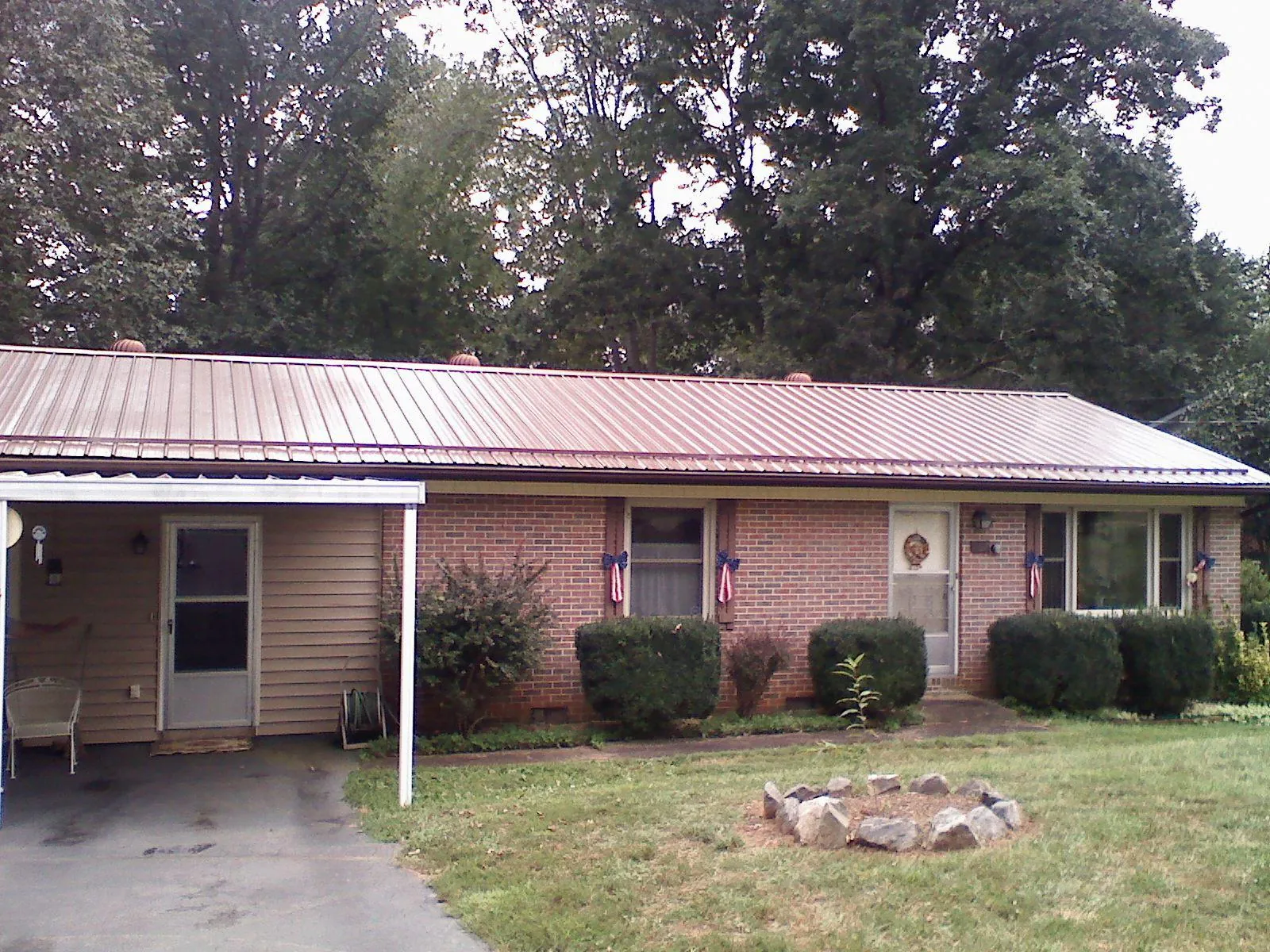 Bronze metal roof and carport on a brick ranch home — Roof Repair work by our crew in Avinger